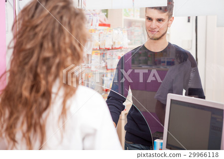 Pharmacist woman and a client in front of the shop 29966118