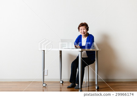 An elderly woman using a personal computer 29966174