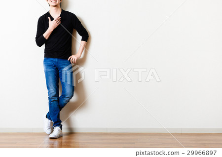 男人站在房間的牆前，牛仔褲 29966897
