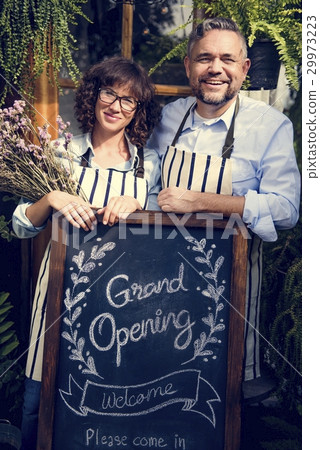 Adult Man and Woman Standing with Grand Opening Sign 29973223