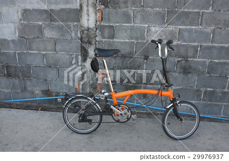 Orange folding bicycle on the road 29976937