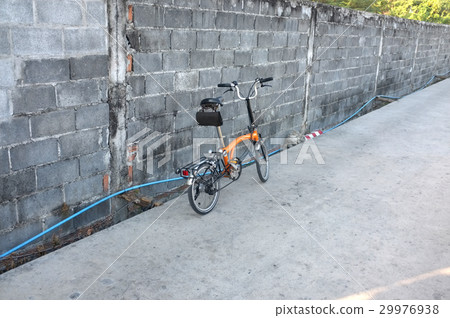 Orange folding bicycle on the road 29976938