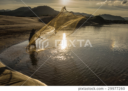 Fisherman in action when fishing in the lake Fisherman in action when fishing in the lake 29977260