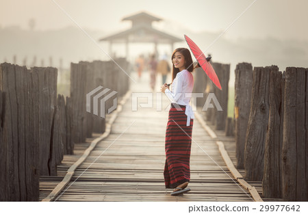 Burmese woman holding traditional red umbrella 29977642