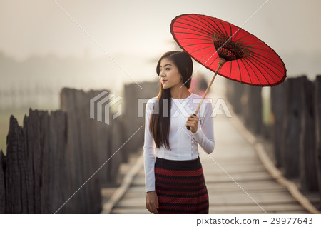 Burmese woman holding traditional red umbrella 29977643