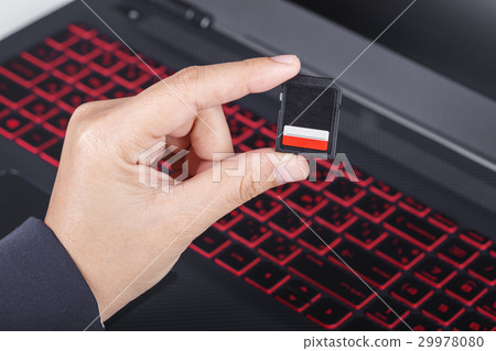 hand holding SD card with laptop hand holding SD card with laptop 29978080