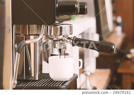 Coffee flowing into a cup from espresso machine Coffee flowing into a cup from espresso machine 29979181
