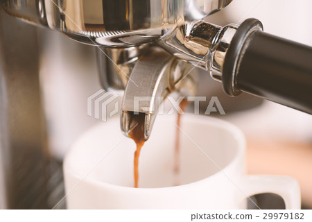 Coffee flowing into a cup from espresso machine Coffee flowing into a cup from espresso machine 29979182