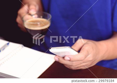 Man using smart phone for working and drink coffee Man using smart phone for working and drink coffee 29979184