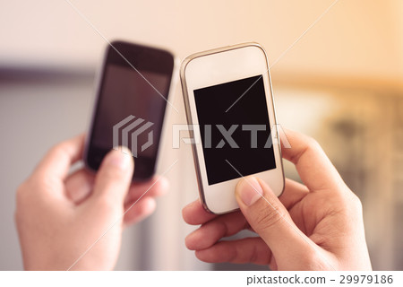 Hand holding two smart phone to sharing data Hand holding two smart phone to sharing data 29979186