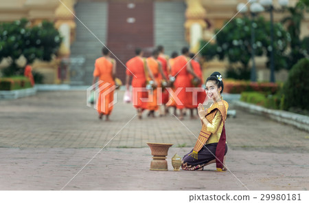 Woman give food offerings to Buddhist monks. 29980181