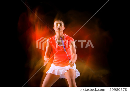 Young woman playing badminton over black Young woman playing badminton over black 29980878