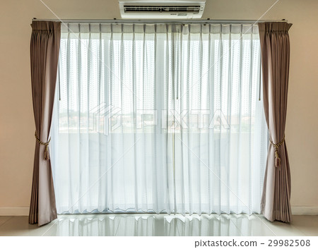 Light shines through white curtains in room 29982508