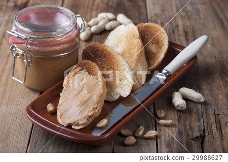 Toasts with peanut butter on a clay plate 29988627