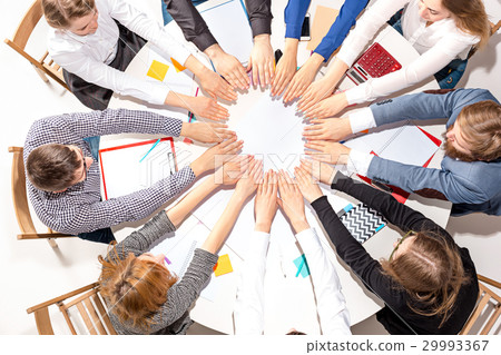 Team sitting behind desk, checking reports 29993367