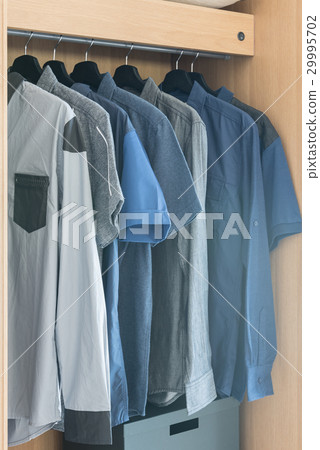 clothes hanging on rail in wooden wardrobe clothes hanging on rail in wooden wardrobe 29995702