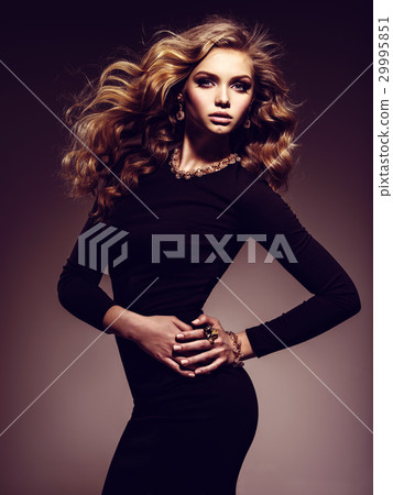 Beautiful woman in black bodycon dress with long curly hair Beautiful woman in black bodycon dress with long curly hair 29995851