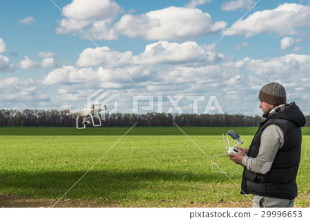 man operating of flying drone quadrocopter at the man operating of flying drone quadrocopter at the 29996653