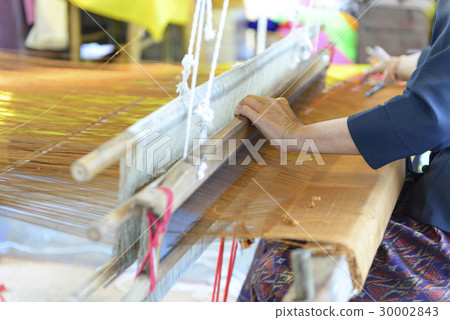 Close up of gold silk weaving on loom Close up of gold silk weaving on loom 30002843