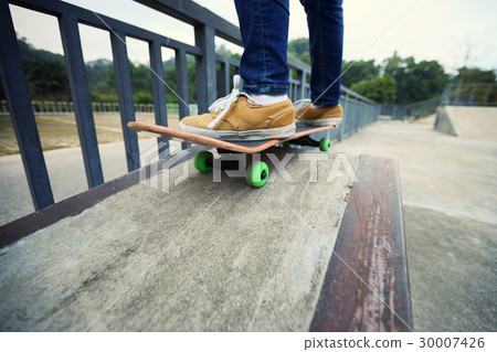 skateboarder legs riding skateboard at skatepark 30007426