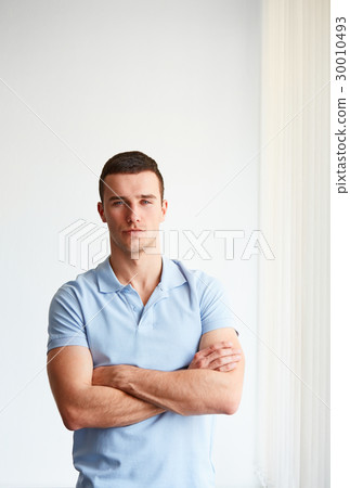 Young businessman standing in an office Young businessman standing in an office 30010493