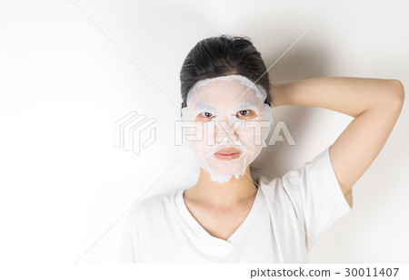 Asian girl in putting on a skin care paper mask 30011407