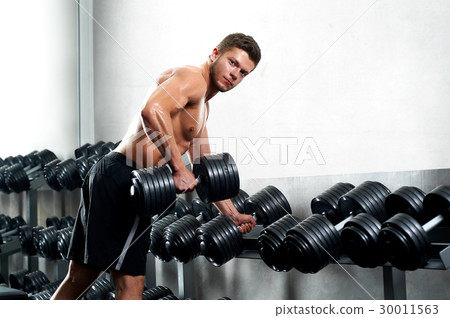Handsome young athlete working out at the gym  30011563