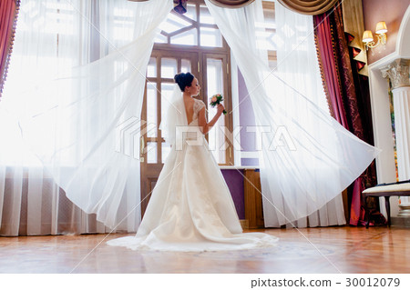 Portrait of a bride in a dress with a long train 30012079