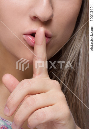 Close-up image of woman with finger on her lips 30013404