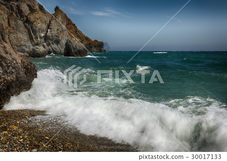 Rocky seashore and waves on a sunny day Rocky seashore and waves on a sunny day 30017133