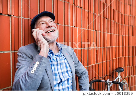 Senior man with smartphone and bicycle against Senior man with smartphone and bicycle against 30018399