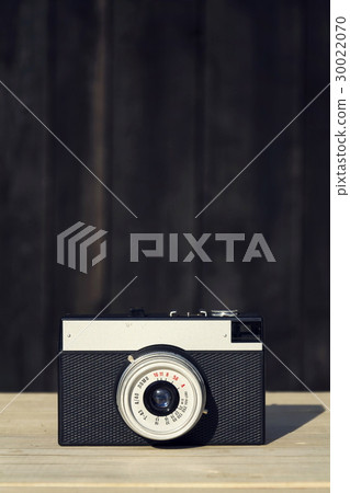 Old vintage filtered camera on wooden background Old vintage filtered camera on wooden background 30022070