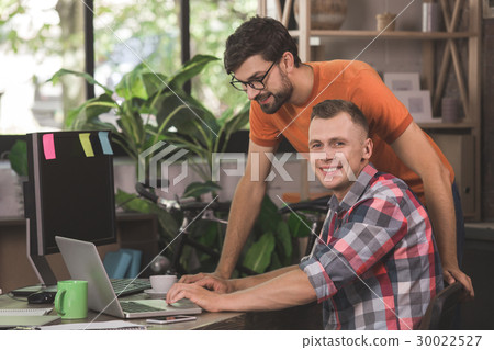 Young men programmers working together in the Young men programmers working together in the 30022527