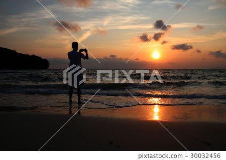 photographer take pictures of sunrise on the beach 30032456