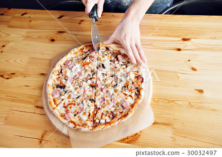 the disc knife cuts. Homemade Pizza with ham the disc knife cuts. Homemade Pizza with ham 30032497