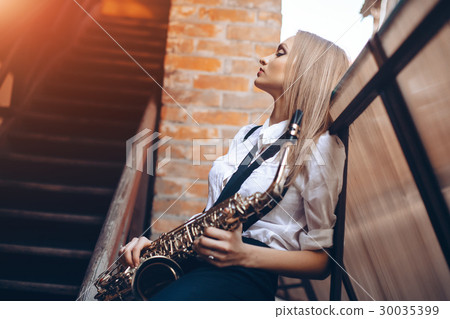 Profile portrait young girl with a saxophone 30035399