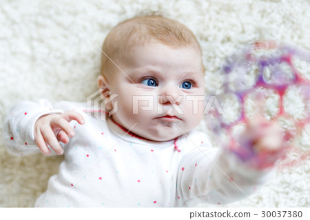 Cute baby girl playing with colorful rattle toy Cute baby girl playing with colorful rattle toy 30037380