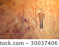 Steel Key hanging on a hook in wooden wall. 30037406