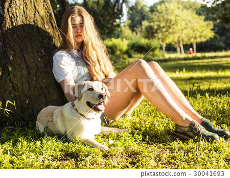 young attractive blond woman playing with her dog young attractive blond woman playing with her dog 30041693