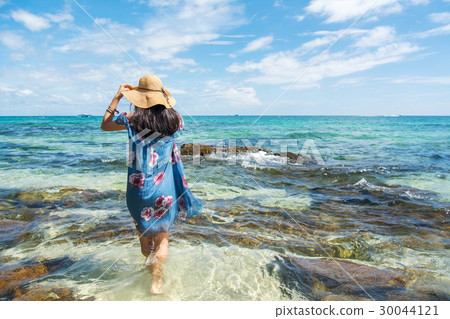 Girl standing in the sea wearing blue dress. Girl standing in the sea wearing blue dress. 30044121