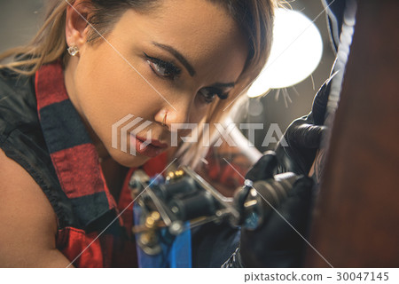 Calm woman making picture on body client 30047145