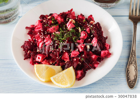 Beetroot salad with lemon and feta on white plate 30047838