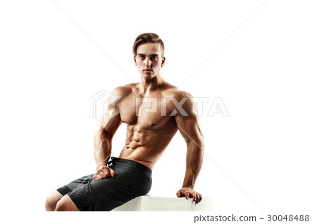 Handsome muscular male model sitting on a cube and Handsome muscular male model sitting on a cube and 30048488