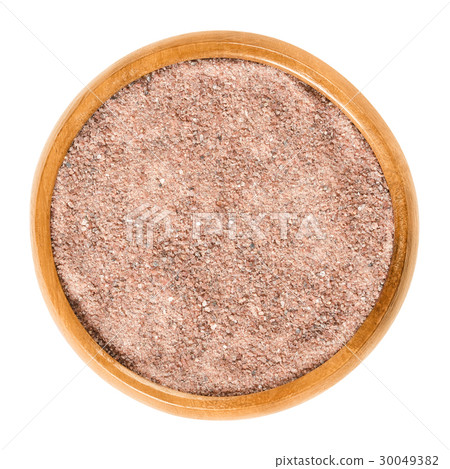 Kala Namak salt powder in wooden bowl over white 30049382