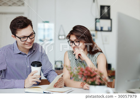 Two creative designers working at white office. 30057979