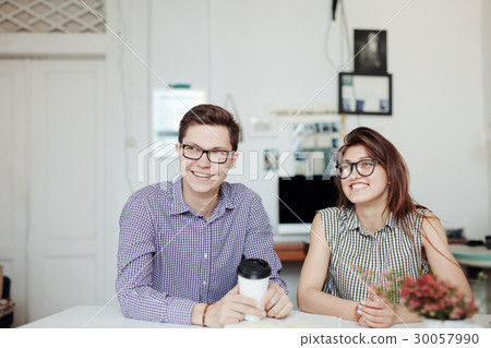 Two creative designers working at white office. 30057990