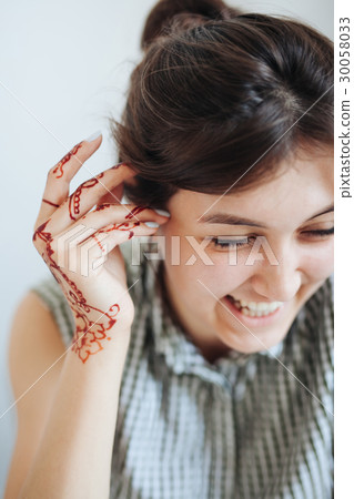 Beautiful girl in white room, with mehendi on hand Beautiful girl in white room, with mehendi on hand 30058033