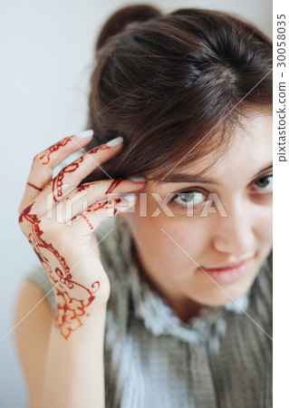 Beautiful girl in white room, with mehendi on hand Beautiful girl in white room, with mehendi on hand 30058035