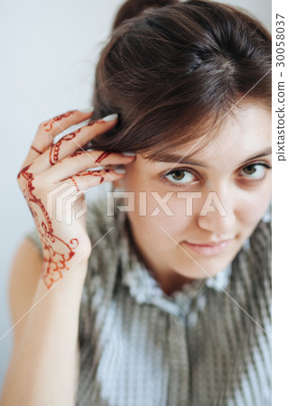 Beautiful girl in white room, with mehendi on hand Beautiful girl in white room, with mehendi on hand 30058037