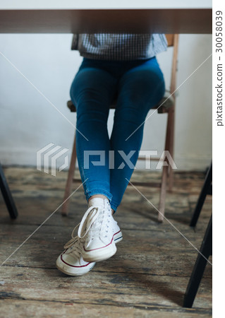 Close up of female legs with shoes under table Close up of female legs with shoes under table 30058039